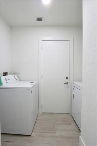 a utility room with cabinets washer and dryer