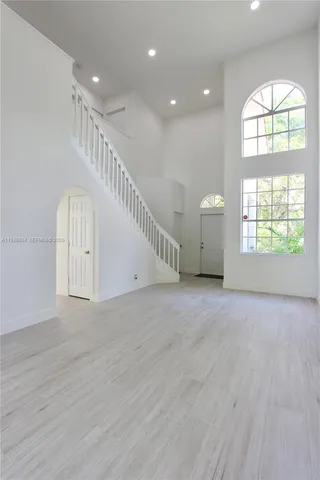 an entryway in a room with a window and wooden floor