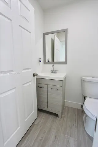a bathroom with a toilet a sink and mirror