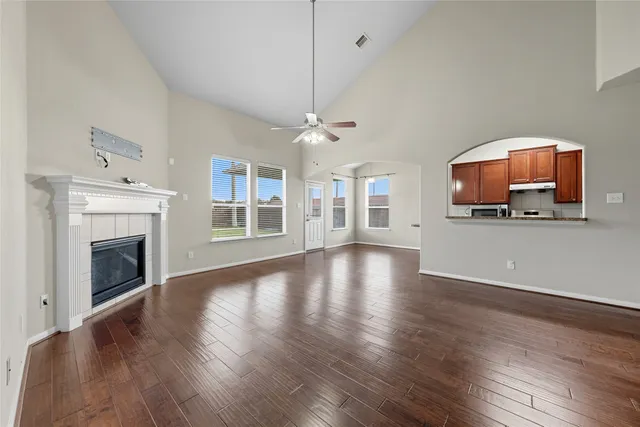 a view of a livingroom with wooden floor and a fireplace