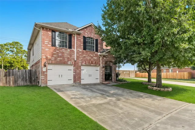 a front view of a house with a yard and tree