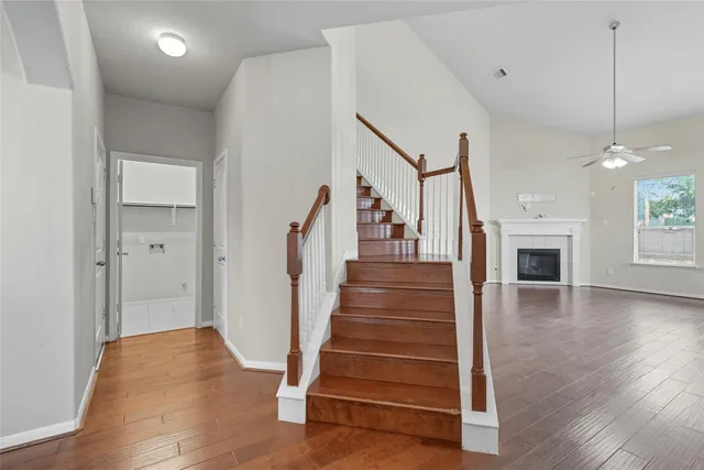 a view of a livingroom with wooden floor and a ceiling fan