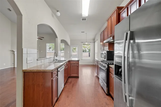 a kitchen with stainless steel appliances a sink stove and refrigerator