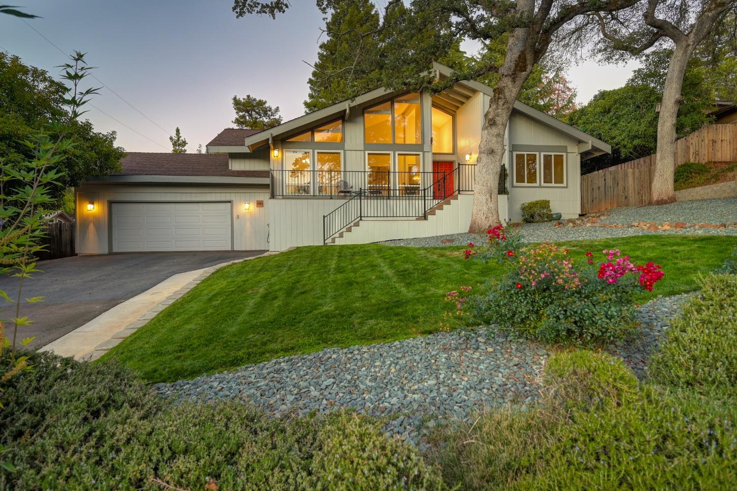 a front view of a house with a big yard and potted plants