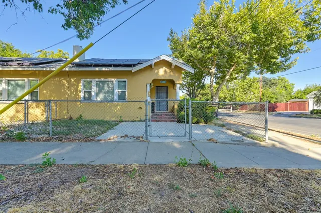 a view of a house with backyard and tree
