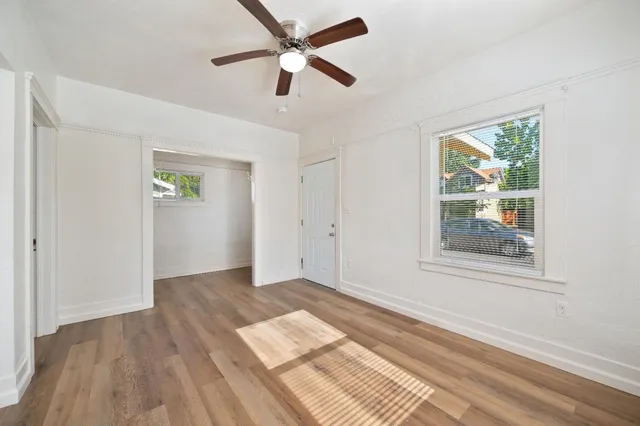 an empty room with wooden floor and a window