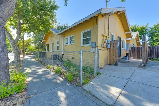 a view of a house with a yard and large tree