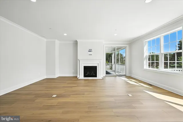 a view of an empty room with a fireplace and a window