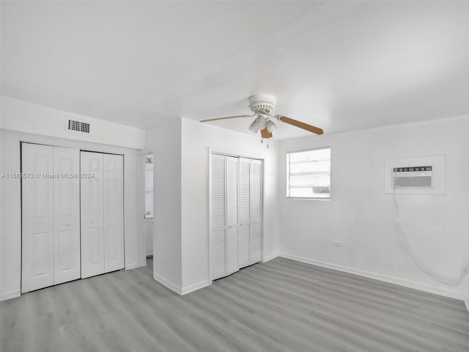 265 East 7th Street Hialeah, FL 33010 - Photo 18 of 28 an empty room with wooden floor closet and windows