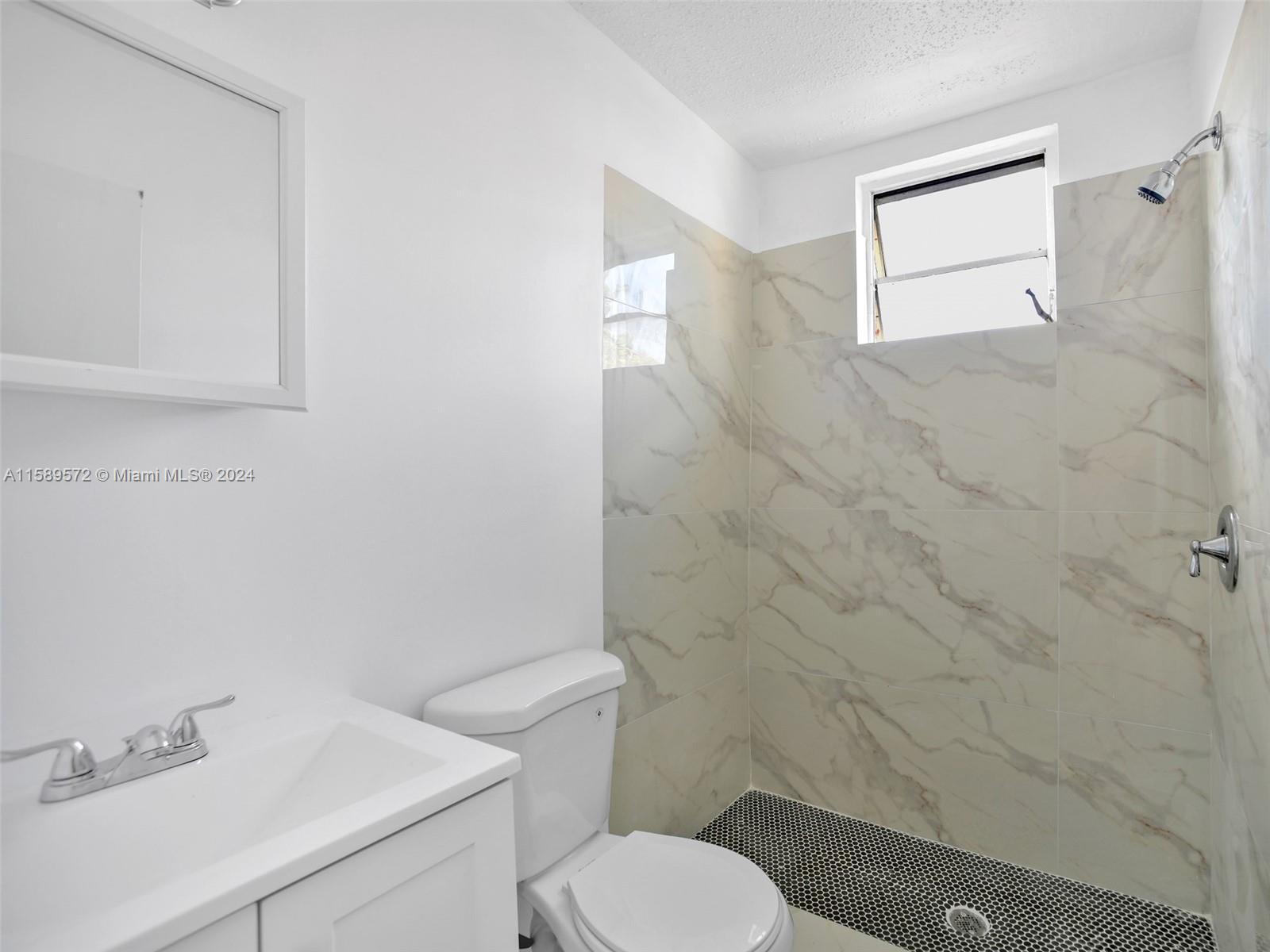 265 East 7th Street Hialeah, FL 33010 - Photo 19 of 28 a bathroom with a toilet sink and mirror