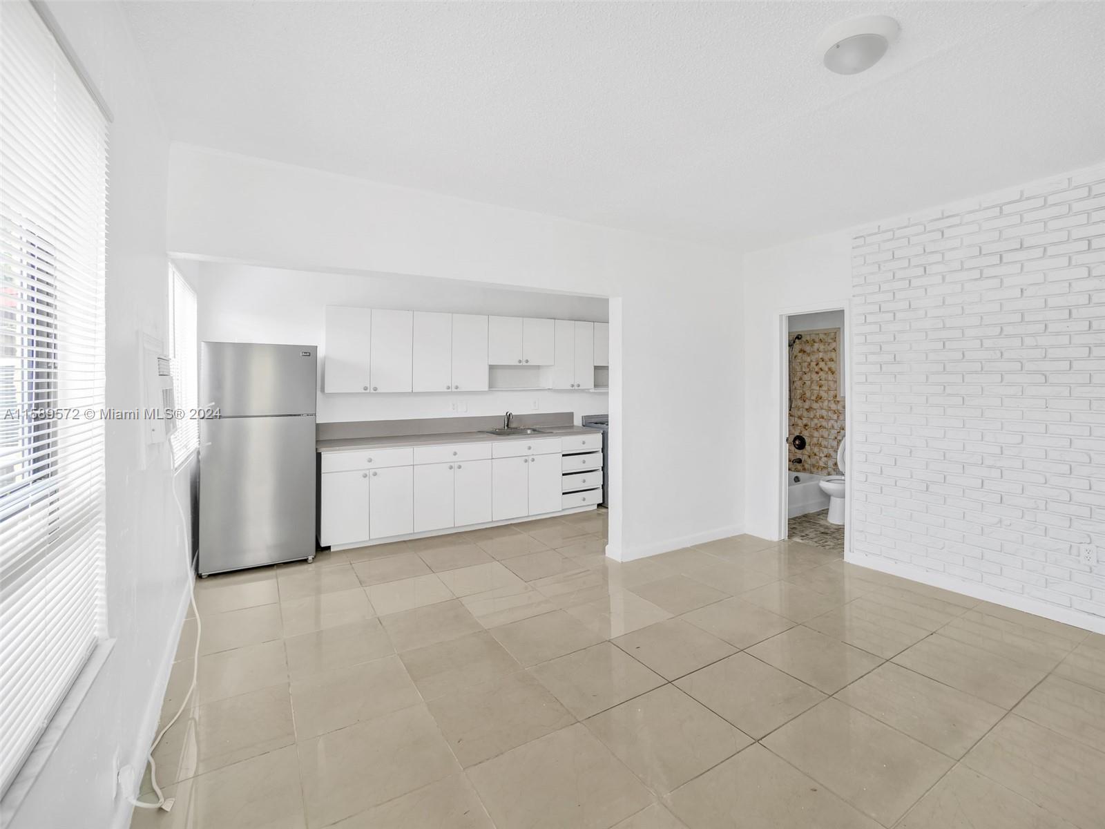 265 East 7th Street Hialeah, FL 33010 - Photo 2 of 28 a view of a kitchen with white cabinets and refrigerator