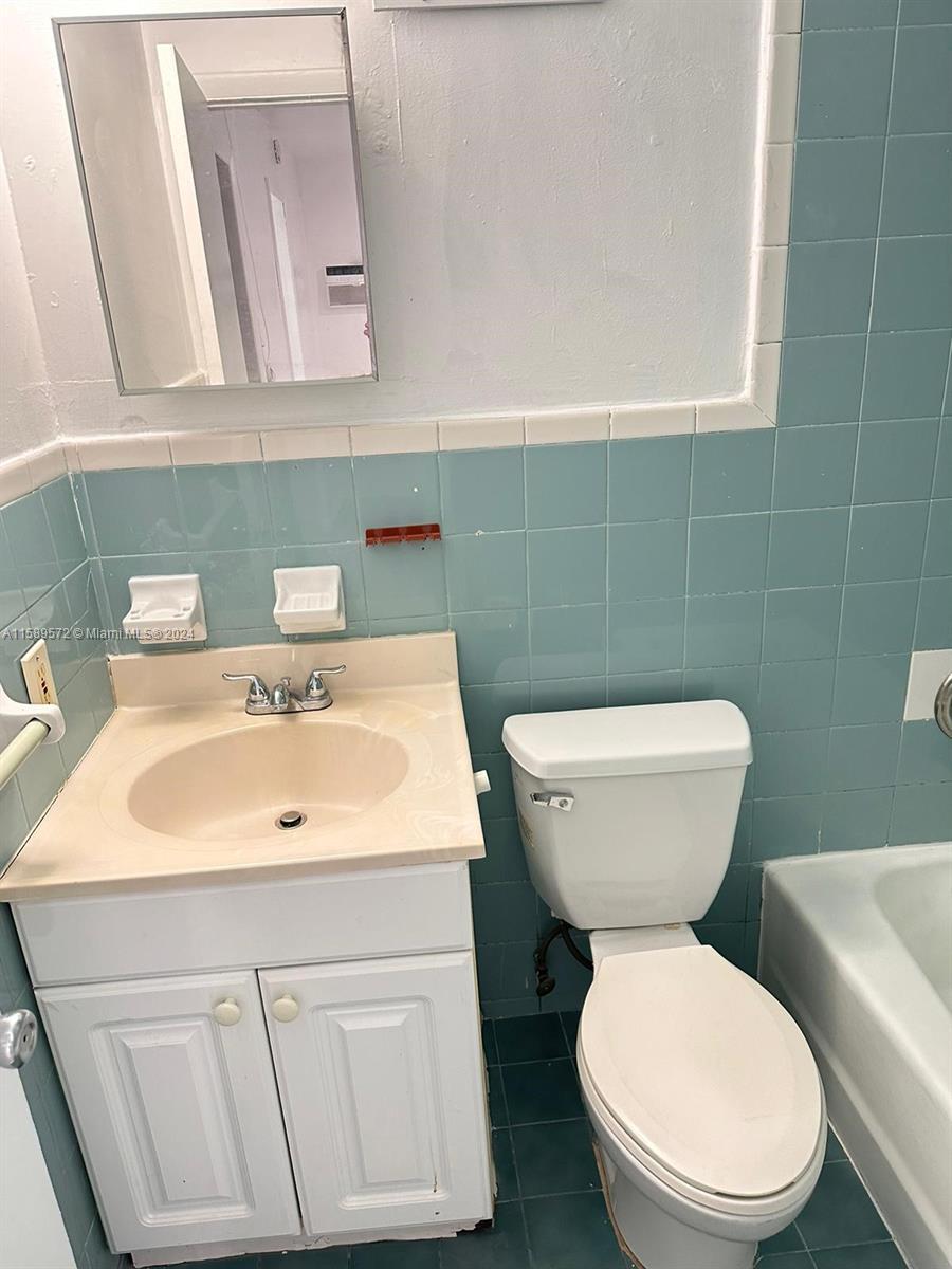 265 East 7th Street Hialeah, FL 33010 - Photo 27 of 28 a bathroom with a toilet sink and mirror