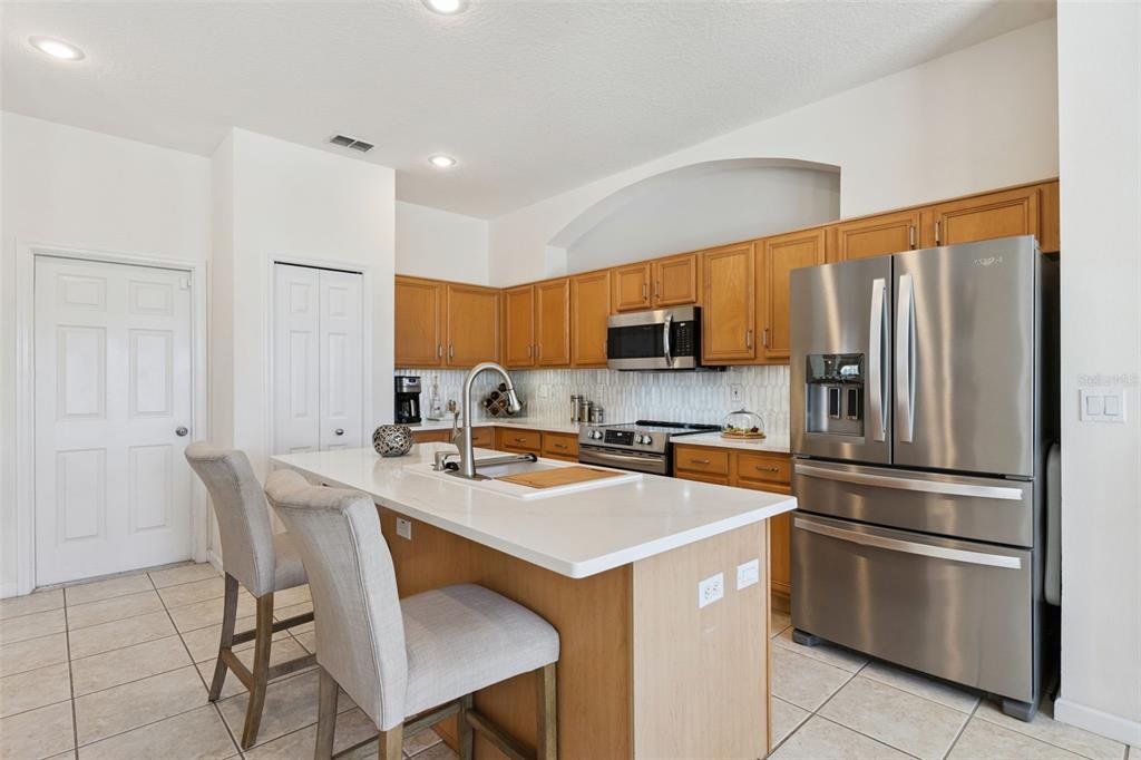 13319 Via Roma Circle Clermont, FL 34711 - Photo 14 of 43 a kitchen with stainless steel appliances a refrigerator stove microwave and sink