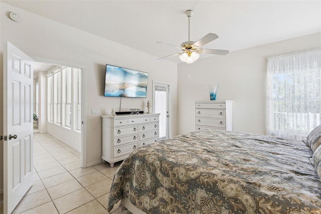 13319 Via Roma Circle Clermont, FL 34711 - Photo 18 of 43 a bedroom with a bed and a chandelier