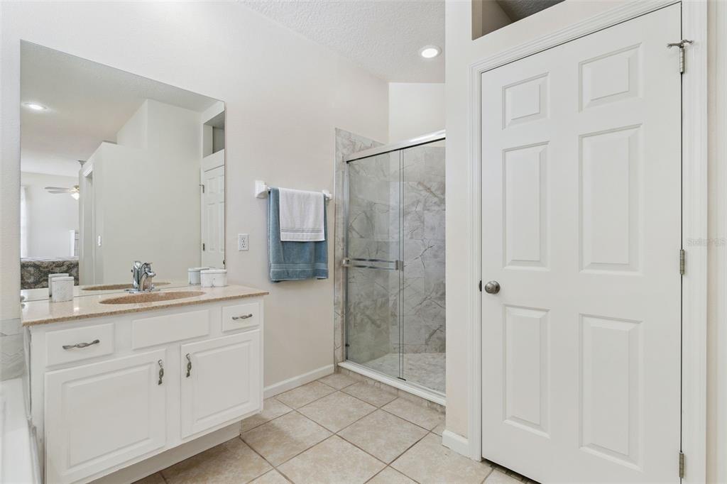 13319 Via Roma Circle Clermont, FL 34711 - Photo 20 of 43 a spacious bathroom with a shower sink and mirror