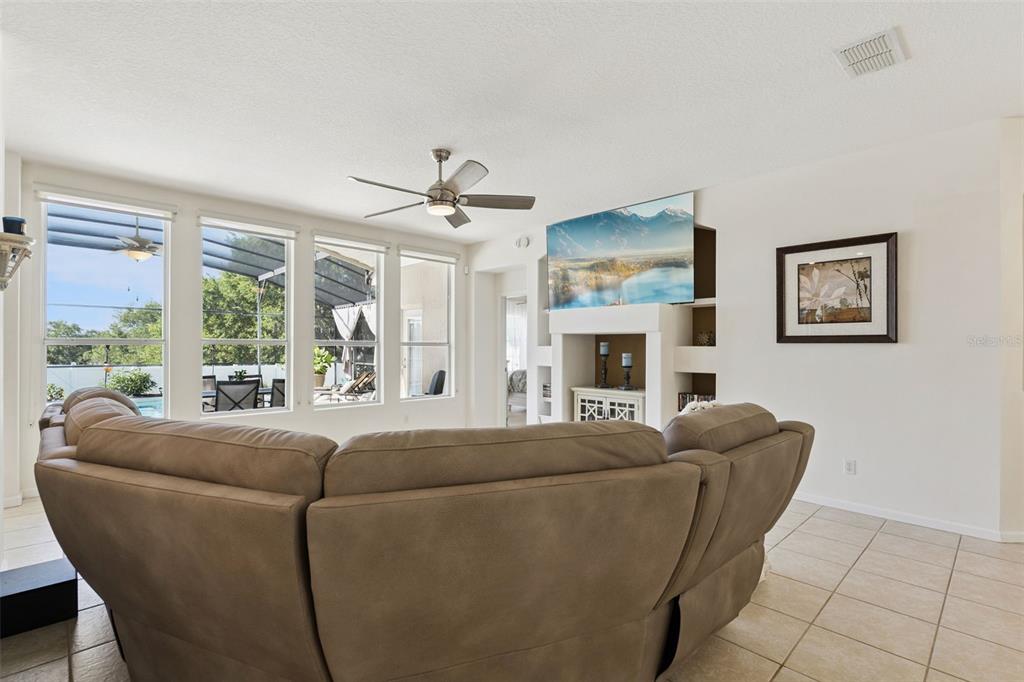 13319 Via Roma Circle Clermont, FL 34711 - Photo 10 of 43 a living room with furniture a fireplace and a large window