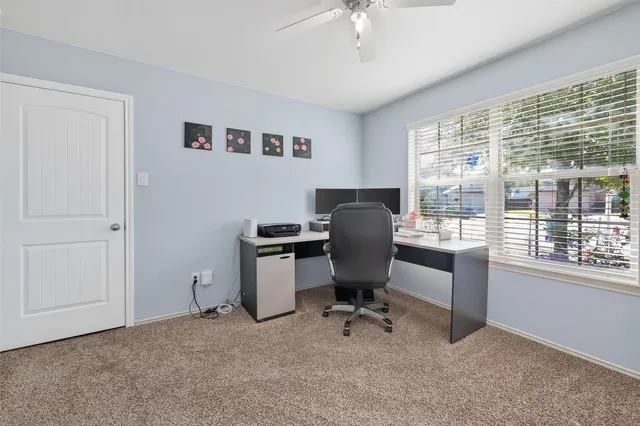 a view of a workspace with furniture and a window