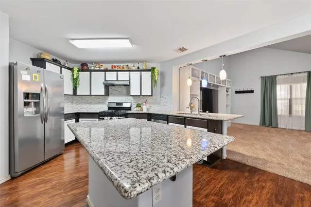 a kitchen with granite countertop a stove and refrigerator