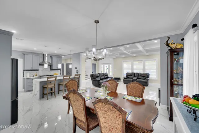 a kitchen with stainless steel appliances kitchen island granite countertop a table chairs sink and cabinets