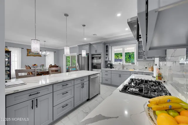 a kitchen with stainless steel appliances granite countertop a stove a refrigerator a sink a stove and white cabinets