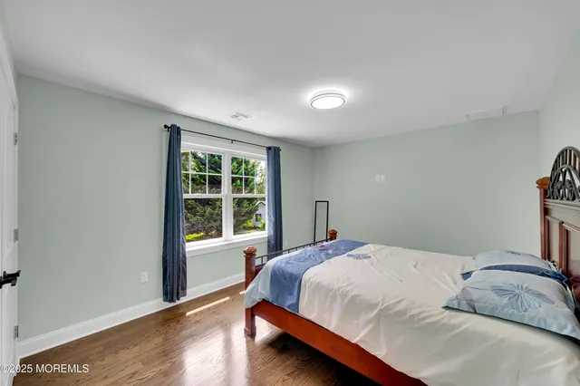 a kitchen with stainless steel appliances kitchen island granite countertop a refrigerator a sink a stove and oven with wooden floor