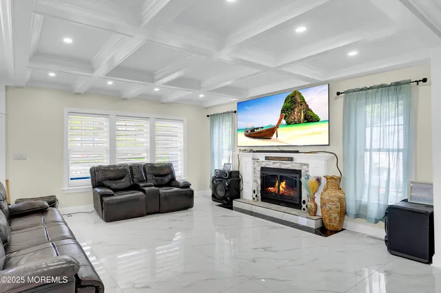 a living room kitchen with stainless steel appliances kitchen island granite countertop a dining table chairs refrigerator and sink