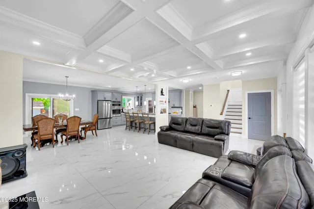 a view of a dining room with furniture a chandelier and wooden floor