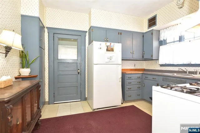 a kitchen with a refrigerator sink stove and cabinets