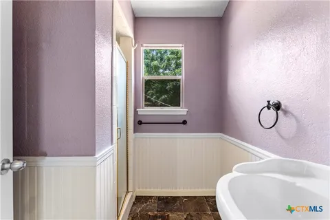 a view of an empty room with a fireplace and a window