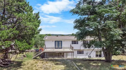 a view of a house with a small yard and wooden fence