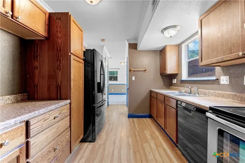 a kitchen with stainless steel appliances granite countertop wooden cabinets stove top oven and sink