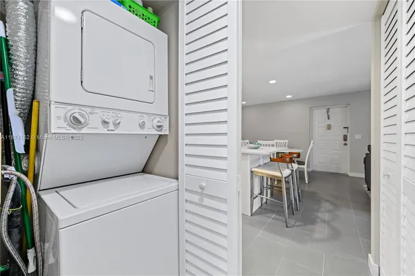 a view of washer and dryer with bathroom in the background