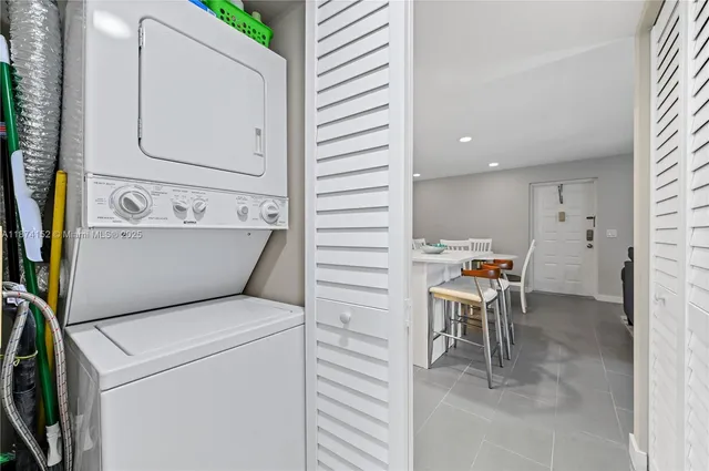 a view of washer and dryer with bathroom in the background