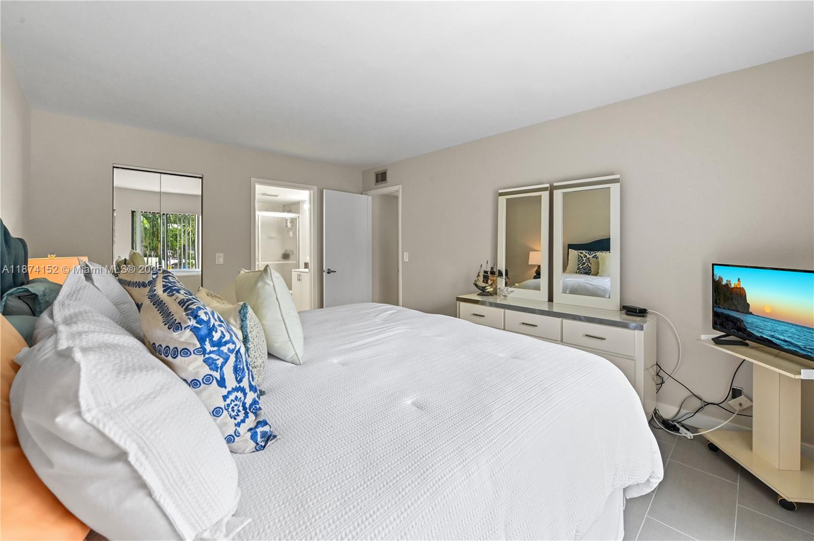 812 Sky Pine Way, Unit C2 Greenacres, FL 33415 - Photo 20 of 25 a bedroom with a bed and a flat screen tv