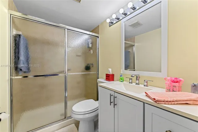 a bathroom with a sink vanity mirror and toilet