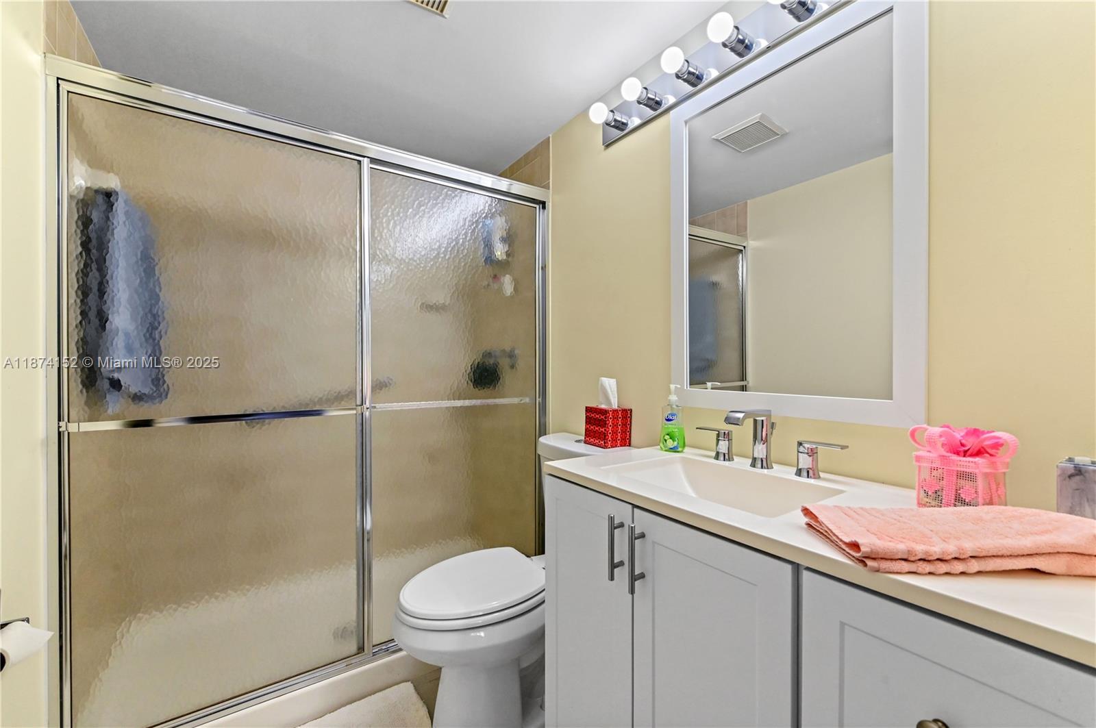 812 Sky Pine Way, Unit C2 Greenacres, FL 33415 - Photo 21 of 25 a bathroom with a sink vanity mirror and toilet