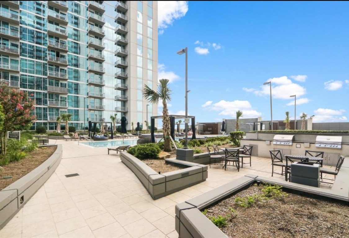 5925 Almeda Road, Unit 12607 Houston, TX 77004 - Photo 2 of 3 a living room with couches a table and chairs with potted plants