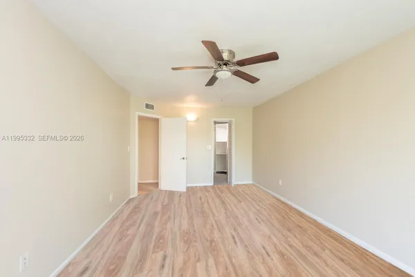 a view of empty room with wooden floor