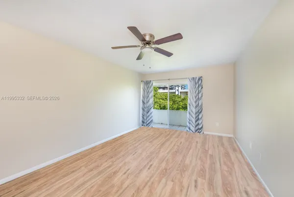a view of a room with a window and a ceiling fan