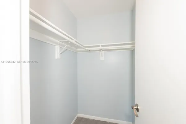 an empty room with a window and a ceiling fan