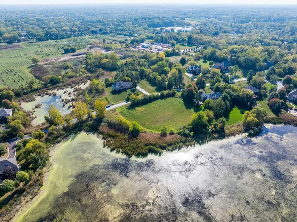 an aerial view of residential house with outdoor space and trees all around