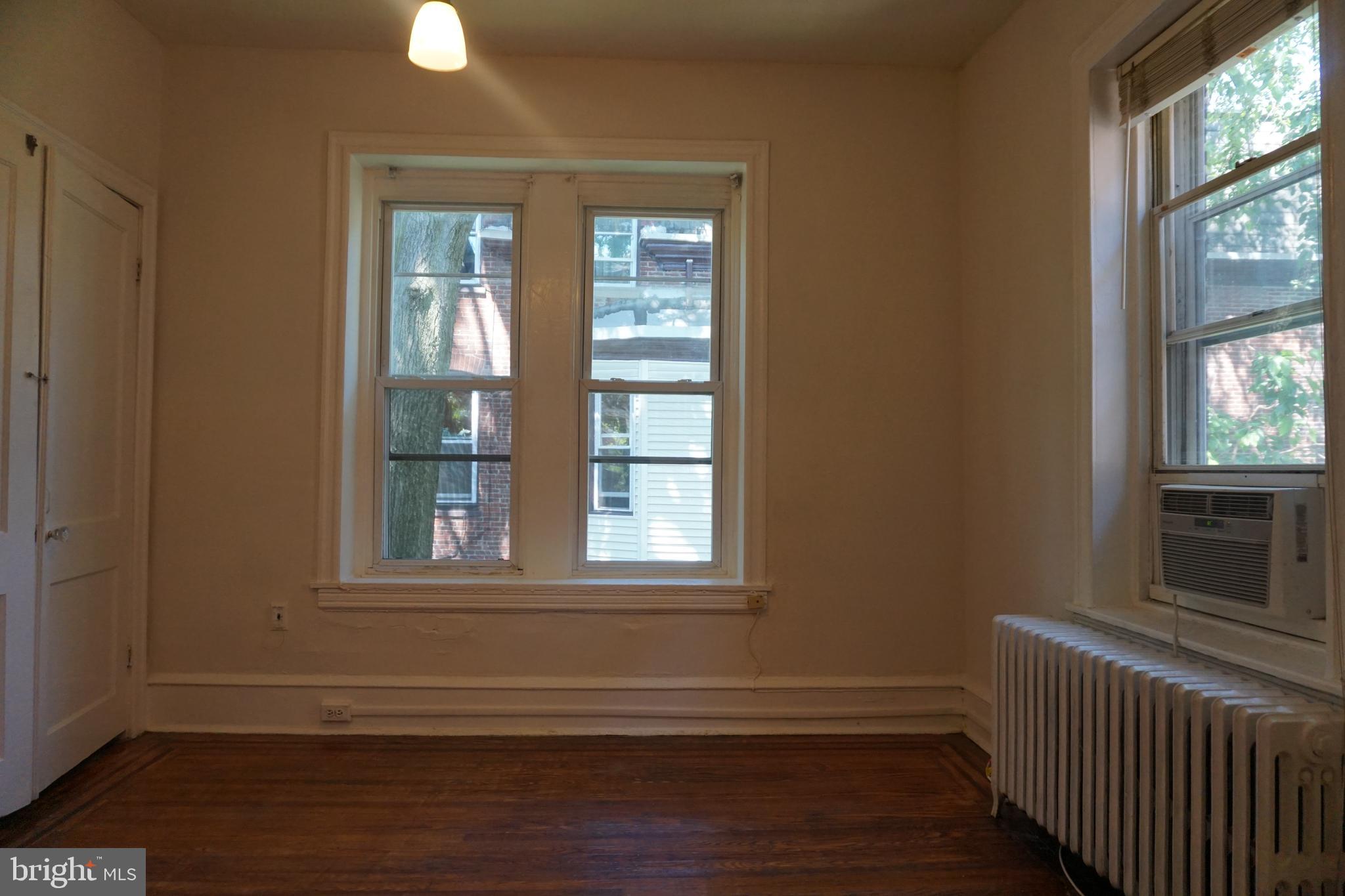 a view of a livingroom with wooden floor and windows