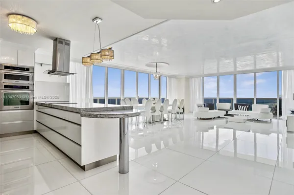 a kitchen with stainless steel appliances kitchen island granite countertop a stove a sink and a refrigerator