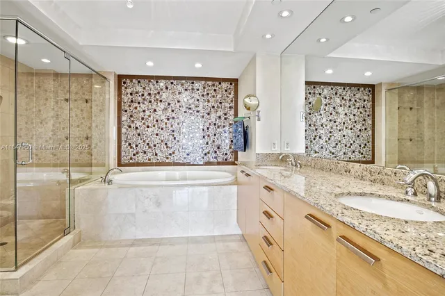 a bathroom with a granite countertop sink a large mirror and a bathtub