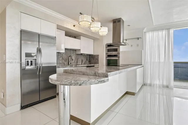a kitchen with kitchen island stainless steel appliances a sink stove and refrigerator
