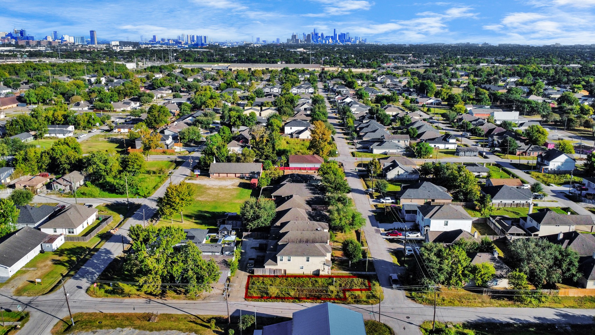 an aerial view of residential houses with outdoor space and trees