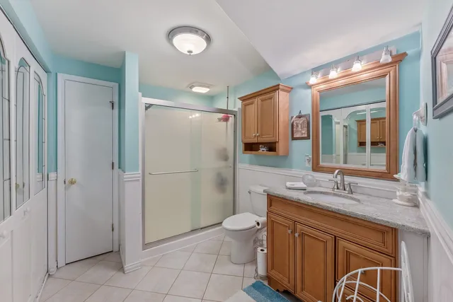 a bathroom with a granite countertop toilet sink and mirror