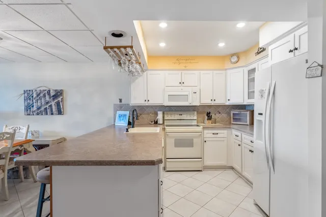 a kitchen with white cabinets and white appliances