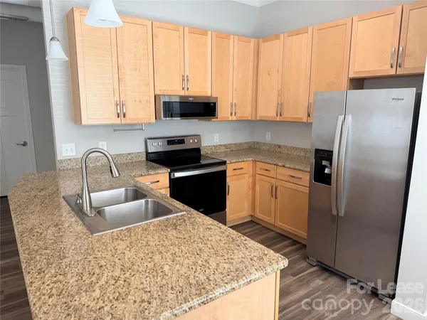 a kitchen with stainless steel appliances granite countertop a refrigerator sink and cabinets