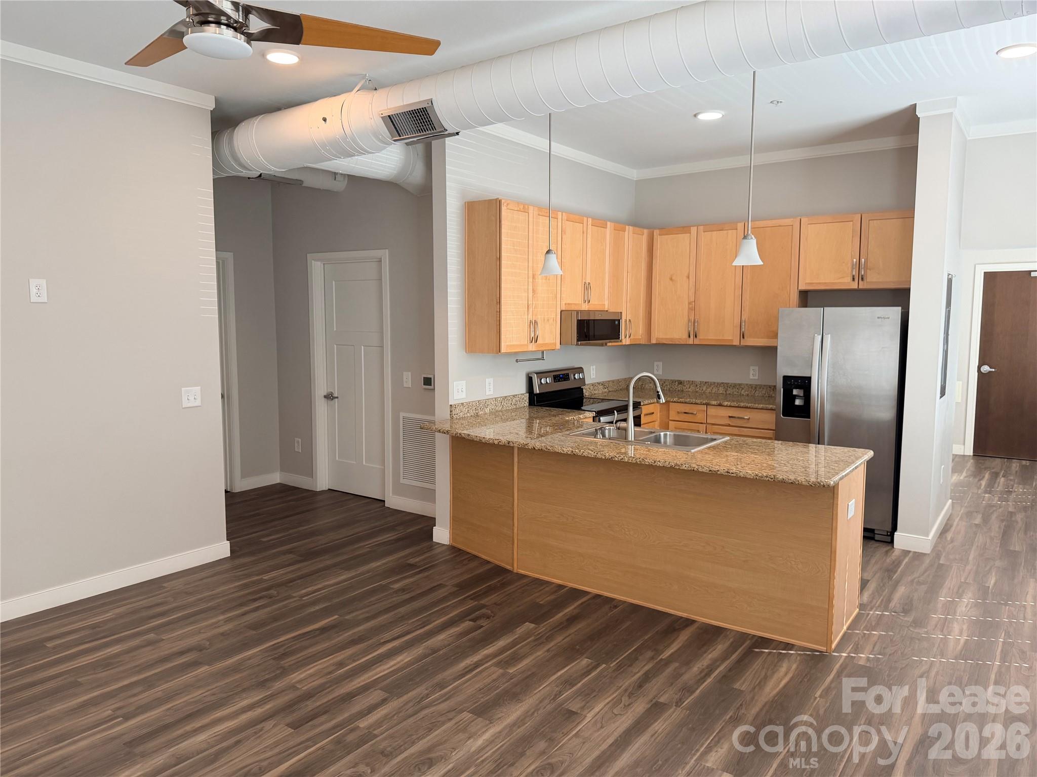 201 East Innes Street, Unit 202 Salisbury, NC 28144 - Photo 9 of 16 a large kitchen with kitchen island a sink stainless steel appliances and cabinets